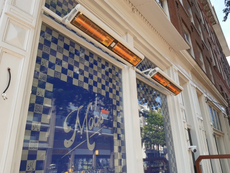 Infrazářič Tansun Monaco XL IPT Carbon 6,0 kW v atmosférické instalaci na rozlehlé hotelové terase – ukázka diskrétního karbonového zářiče s minimálním světelným výstupem a třemi topnými elementy zajišťujícími rovnoměrné teplo na velké ploše