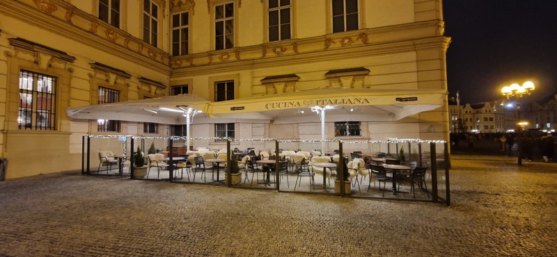 Celkový pohled na vytápěnou předzahrádku restaurace L'Osteria v Paláci Kinských na Staroměstském náměstí v Praze s infrazářiči BURDA TERM 2000 IP67 v bílém provedení
